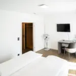 Bequeme Betten im Hotelzimmer mit weißer Bettwäsche