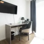 Moderne Hotelzimmer mit Schreibtisch, Stuhl und Fernseher