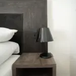 Nahaufnahme von der stylischen Schreibtischlampe neben dem Bett