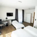 Helles Hotelzimmer mit Schreibtisch, Stuhl und Fensterblick