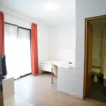 Hotelzimmer mit Einzelbett, Schreibtisch und Bad