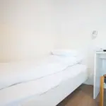 Hotelzimmer mit Einzelbett und Schreibtisch