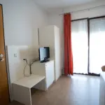 Hotelzimmer mit Kleiderschrank, TV und einem Großen hellen Fenster