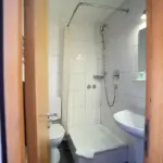 Hotelbadezimmer mit Dusche und WC, modern und einfach eingerichtet