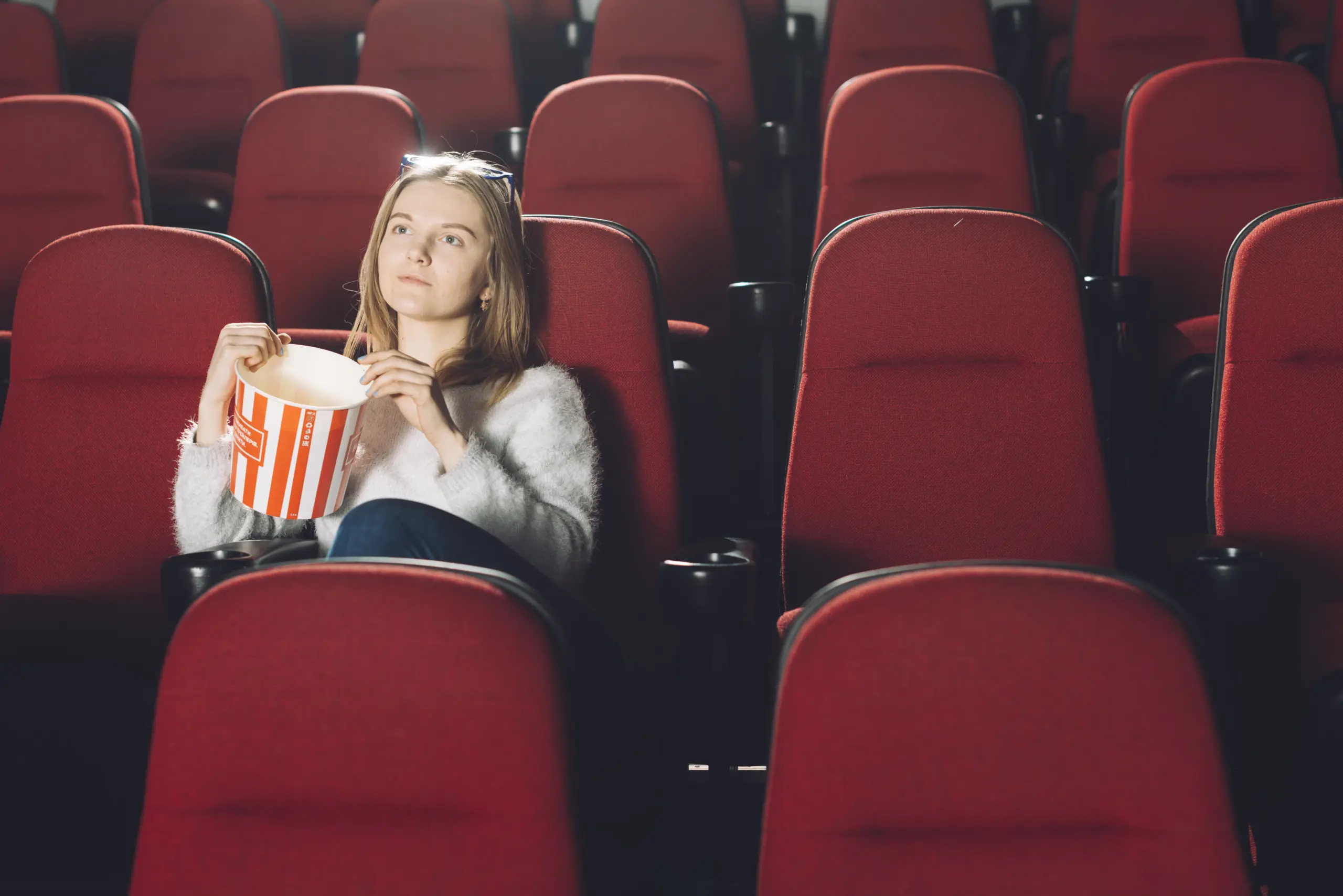 Frau im Kino mit Popkorn in der Hand
