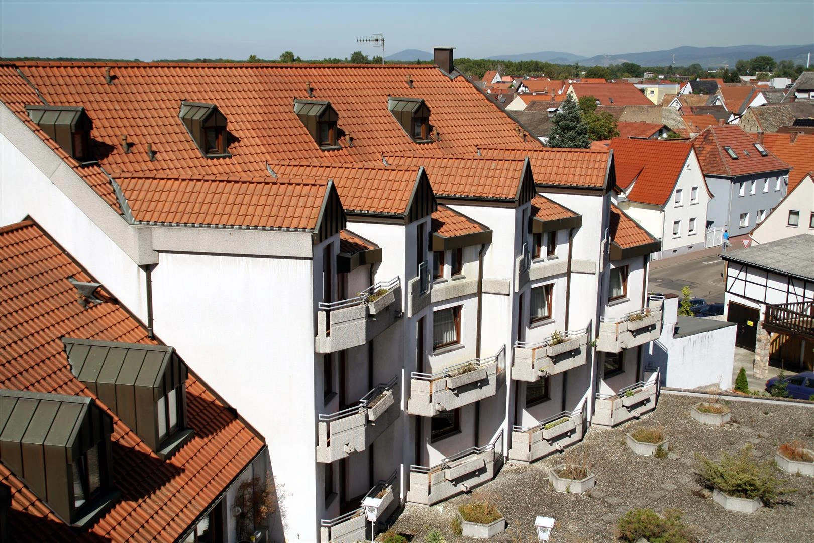 Rückansicht eines Hotels mit Balkonen und rotem Dach