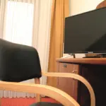 Schreibtisch mit Stuhl und Fernseher in Hotelzimmer