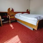 Hotelzimmer mit Doppelbett und rotem Teppich